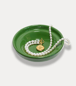 Pearl necklace with moon face on green plate